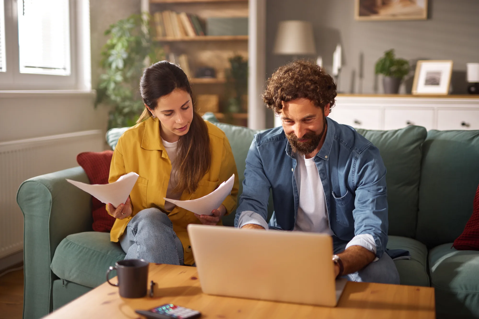 Couple at home reviewing share certificate terms together on a laptop